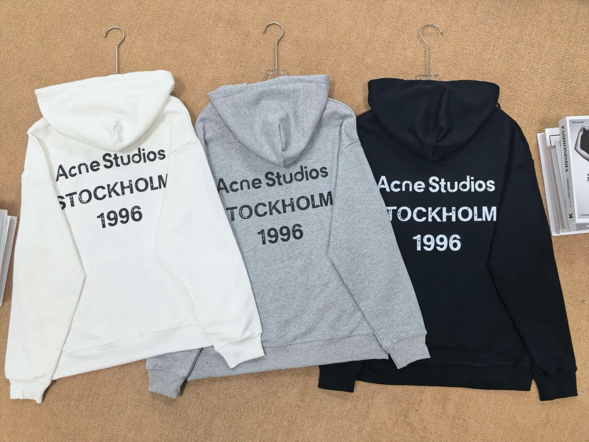 No. 2212 Style: Hooded sweatshirt with letter print on the back Color: Cream White/Flower Gray/Classic Black Version: Loose shoulder Oversize, Same Style for men and women, regardless of body shape Style: Simple Nordic Retro style, casual and high-end sense 🧶Fabric technology • Made of heavyweight knitted terry fabric, which feels thick and soft, stiff and not easy to collapse, suitable for spring and autumn wear alone or for inner wear in winter • Letter printing on the back with an old and worn feel, not a stiff offset printing, durable in washing and not easy to crack and fall off • Hood + drawstring design, threaded cuffs and hem, not easy to deform, temperature-locking and windproof 💡Design Highlights Large "Acne Studios STOCKHOLM" on the back "The Retro logo is a classic element of the brand. It is simple and not exaggerated; it has dropped shoulders and a wide version, which hides the flesh and makes you look slimmer. It is friendly to shoulder width and hip width. The hat shape is three-dimensional and the upper body is very atmospheric. 👕Wearing Scenarios • Everyday: jeans, sports pants, just one set for lazy people when going out • Layering: a base T-shirt inside, and a coat or leather jacket outside • Scenes: commuting, shopping, traveling, campus, male and female couples, can be worn as a couple